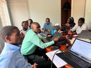 NexusCRI participants working together around a table with laptops, notes and research materials.